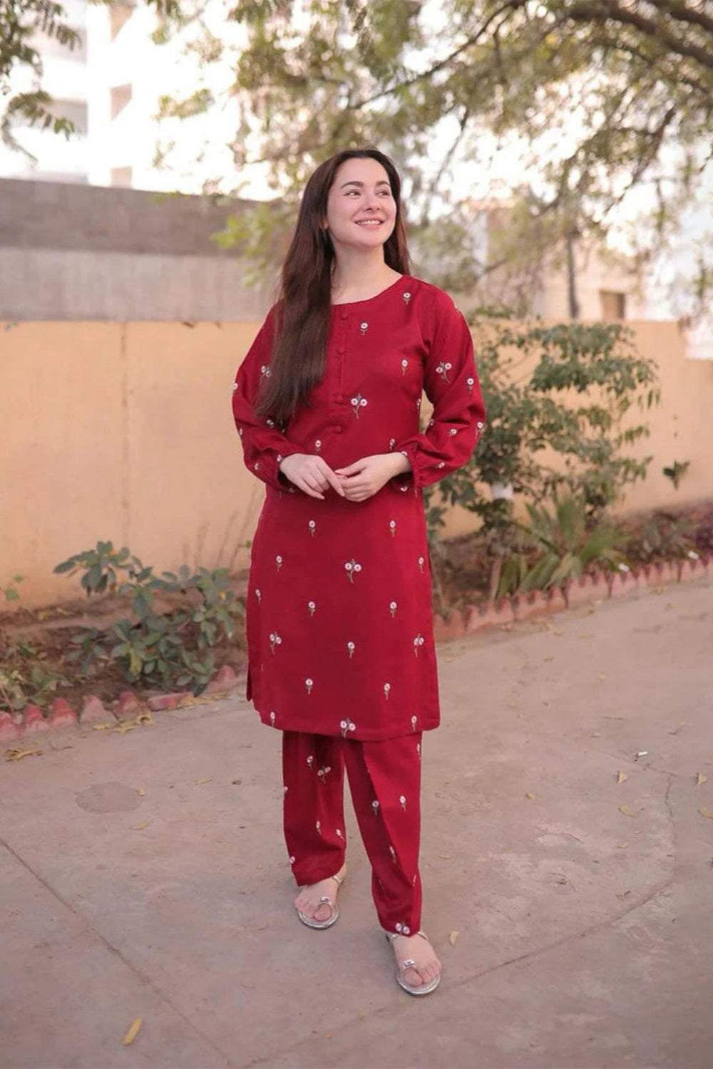 Woman wearing red embroidered Red Rose Lawn 2PC suit with matching trousers outdoors